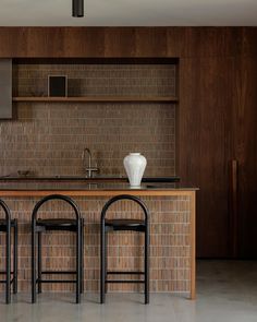 three stools sit in front of a kitchen counter