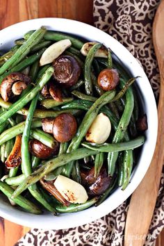 a white bowl filled with green beans and mushrooms