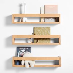 two wooden shelves with books and stuffed animals on them, one shelf has a book