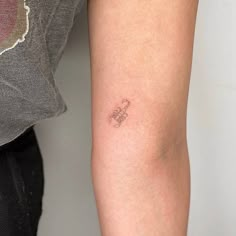 a small tattoo on the arm of a woman's left arm, which has an outline of a flower