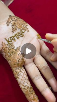 a woman is getting her hand painted with hendi and writing on the side of her hands