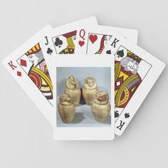 three wooden vases sitting on top of each other in front of two playing cards