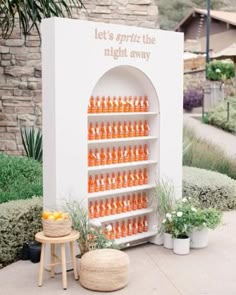 there is a display with oranges and bottles on it in front of a building