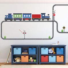 a child's room with a train wall decal and toy storage bins