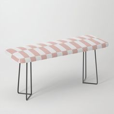 a pink and white checkered bench with metal legs