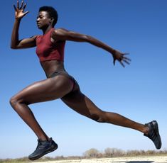 a woman is running on the beach with her hands in the air