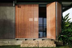 the outside of a house with wooden shutters on it's windows and grass in front