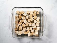 tofu cubes in a glass dish on a white table top view from above