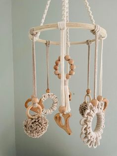 a mobile made out of rope and wood beads with wooden teeth hanging from it's sides