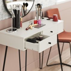 a vanity table with makeup on it in front of a mirror