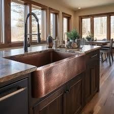 a large kitchen with wooden cabinets and stainless steel sink in it's center island