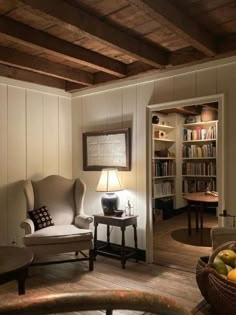 a living room filled with furniture next to a book shelf and a lamp on top of a table