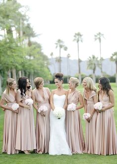 a group of women standing next to each other on top of a lush green field