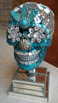 a blue and silver skull statue sitting on top of a counter