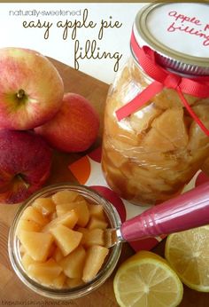 apples and lemons are sitting on a cutting board next to a jar of apple pie filling