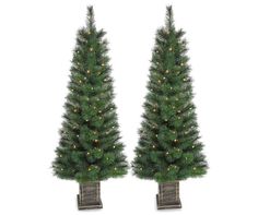 two artificial christmas trees with lights on them