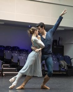 two people are dancing in an auditorium