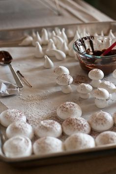 a tray filled with marshmallows on top of a table next to spoons