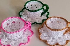 three crocheted cups and saucers sitting next to each other