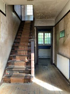 an old house with wooden stairs leading up to the second floor