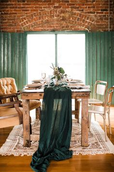 the table is set with plates and silverware, along with a green cloth draped over it