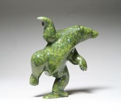 a green statue is standing on its hind legs