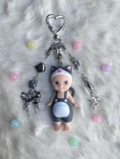 a keychain with a doll on it and some charms attached to the chain