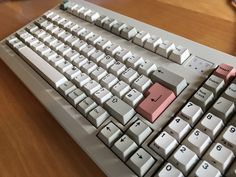 a computer keyboard sitting on top of a wooden table