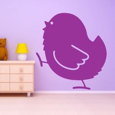 a purple bird wall decal in a child's room with a teddy bear