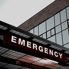 a red emergency sign hanging from the side of a building