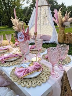 the table is set with pink and gold dishes