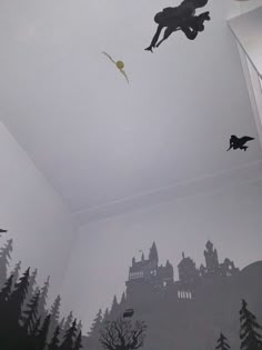 some birds are flying in the sky above a castle wallpapered with black and white silhouettes