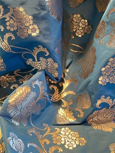 blue and gold brocaded fabric with large floral designs on it's sides