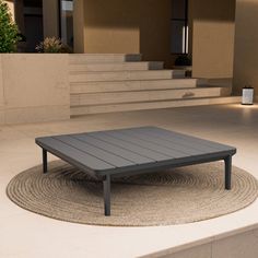 a coffee table sitting on top of a rug in the middle of a patio area