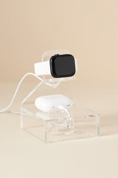 an electronic device sitting on top of a clear stand with a black and white camera attached to it