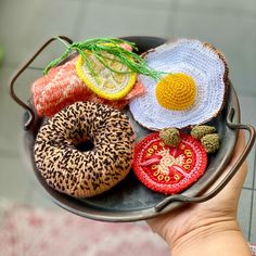 a person holding a plate with donuts and other food items on top of it