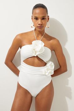 Welcome The Sun With A Swimming Costume That Will Turn Heads, Featuring A Three Dimensional Corsage Accent On The Bust And Hip, And A Statement Cut Out Design In The Front And Back. Style This Piece With Strappy Sandals And A Beach Cover Up For A Holiday Look That Can Be Reworn Time And Time Again. Rosette Cut Out Detail Swimsuit Flattering Halter Neckline Unique, Three Dimensional Flower Accent Statement Cut Out Design Tie And Clasp Fastening In Back One Piece Swimsuit Outfit Cover Up, Wedding Swimsuit, Bride Swimsuit, Bridal Swimsuit, Bali Outfits, Hen Do Outfits, Wine Tasting Outfit, Petite Wedding Guest Dresses, Workwear Capsule Wardrobe