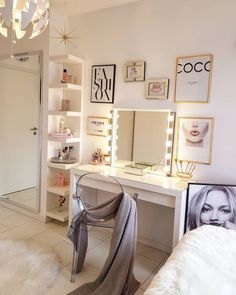 a white vanity with lights and pictures on the wall