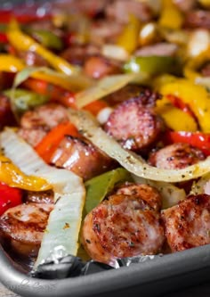 sausages, peppers and onions are being cooked in a pan