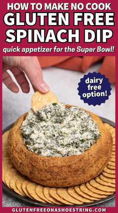 a bread bowl filled with spinach dip surrounded by flat crackers