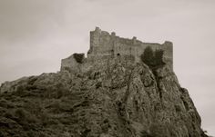 an old castle sitting on top of a mountain