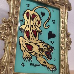 an ornate gold frame with a painting of a tiger on it's face and hearts in the mouth