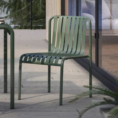 two green chairs sitting next to each other on a sidewalk