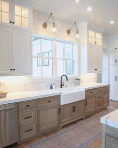 a large kitchen with white cabinets and stainless steel appliances on the counter top, along with a rug