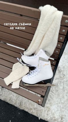 two pairs of ice skates are sitting on a bench with gloves and mittens