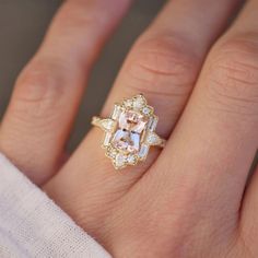 a close up of a person's hand with an engagement ring on their finger