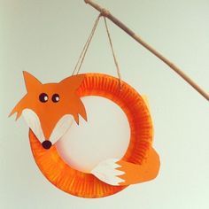 a paper plate fox hanging from a string