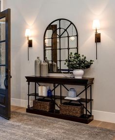 an entryway with a mirror and vase on it