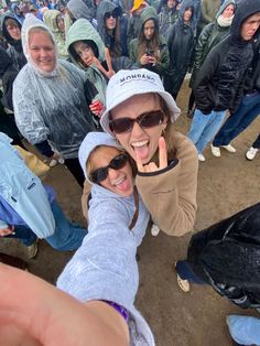 two women taking a selfie in front of a group of people