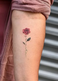 a small rose tattoo on the right arm